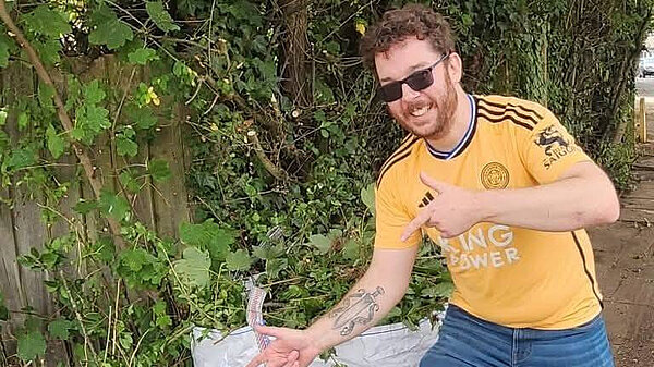 Alex Lock pointing at cleaned up green waste