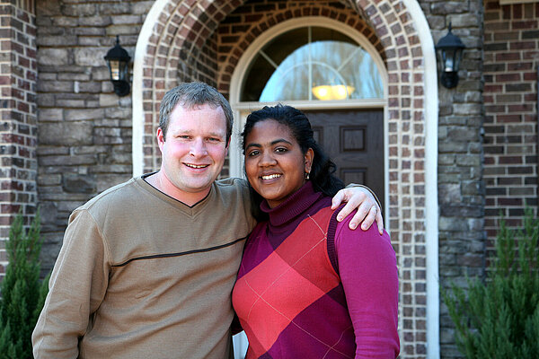 A couple stood outside a house.